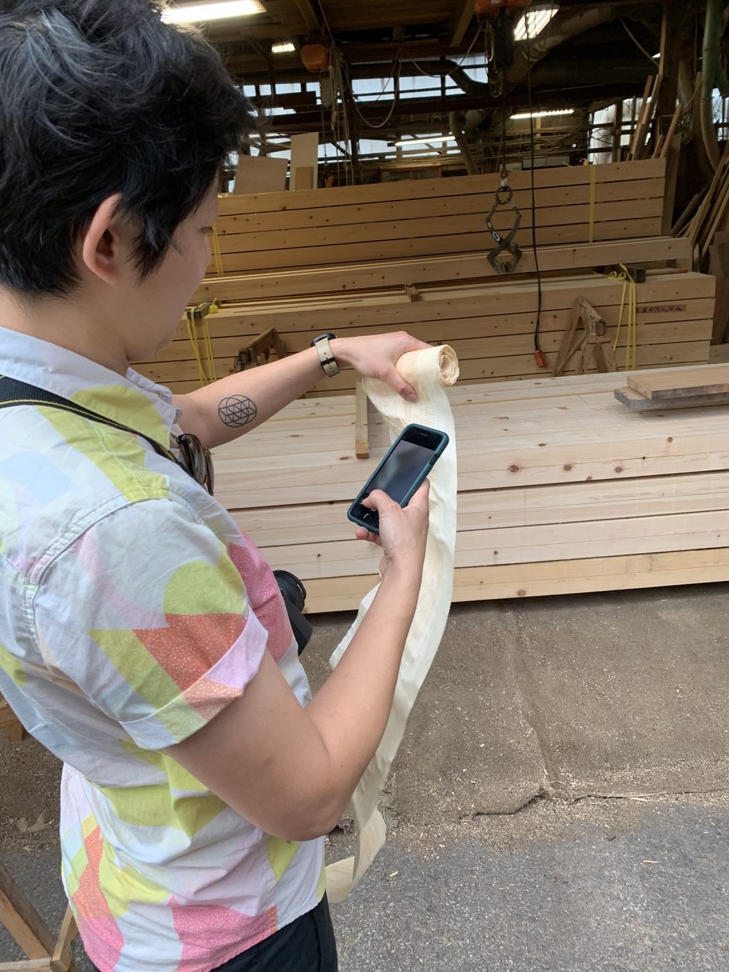 Ayako at lumber mill holding tissue-paper-thin wood shaving