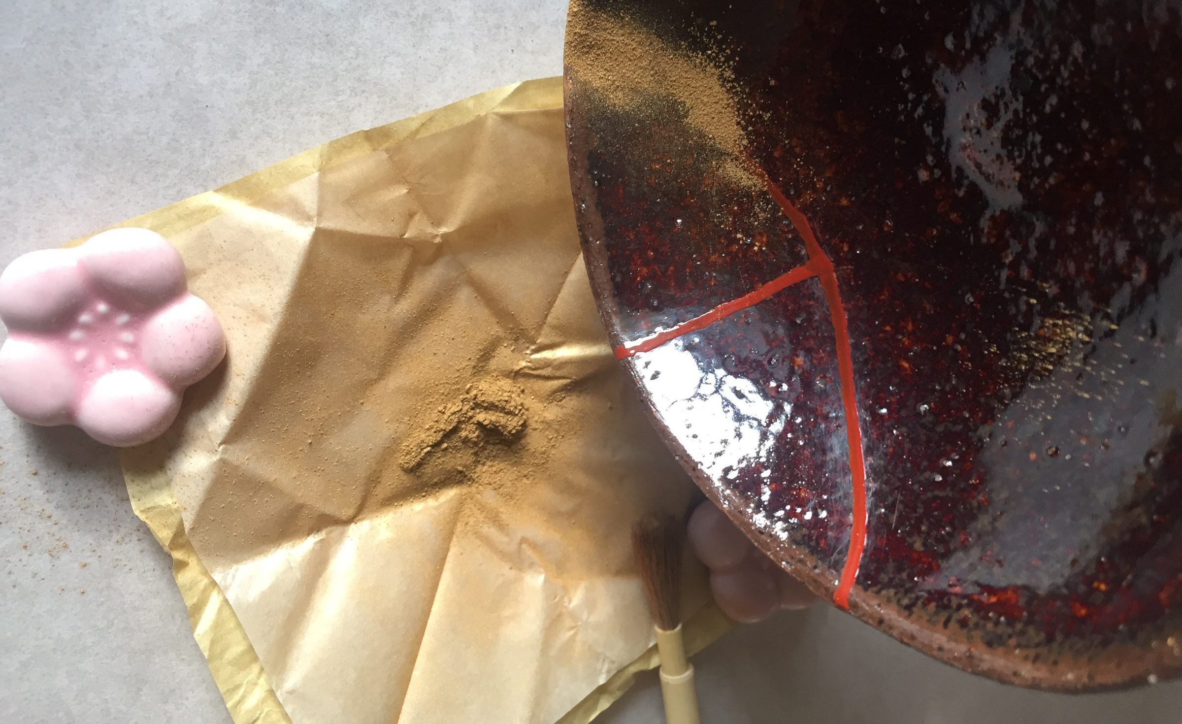 Gold powder being applied to kintsugi bowl with urushi lacquer, Daigo Japan